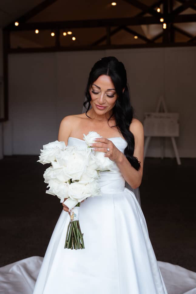 Mel holding her bouquet in the venue